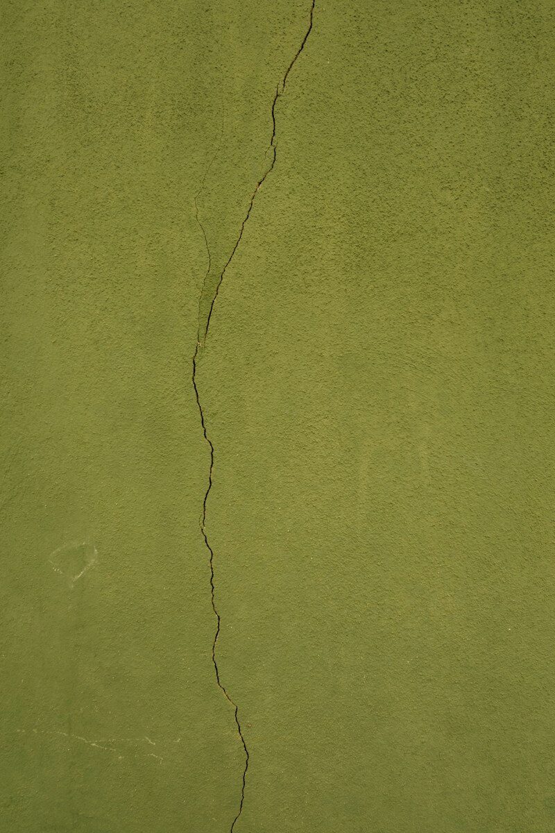 a green wall with a crack in it